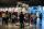 A large number of people in a gallery examining a display comprised of several seemingly ordinary objects